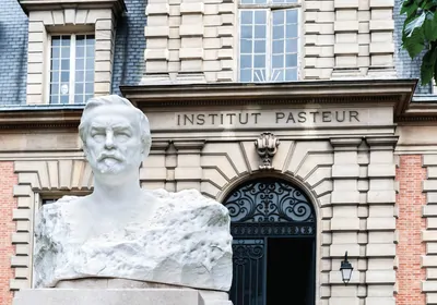 Photo of carved bust in front of building labeled "Institut Pasteur"